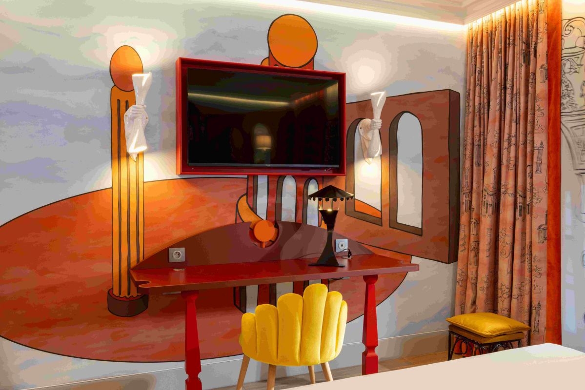 Scrivania di design con decorazioni murali, camera dell'hotel boutique Le Magnifique a Parigi