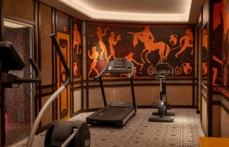 Fully equipped gym and fitness center featuring artistic murals at the Magnifique Paris Hotel